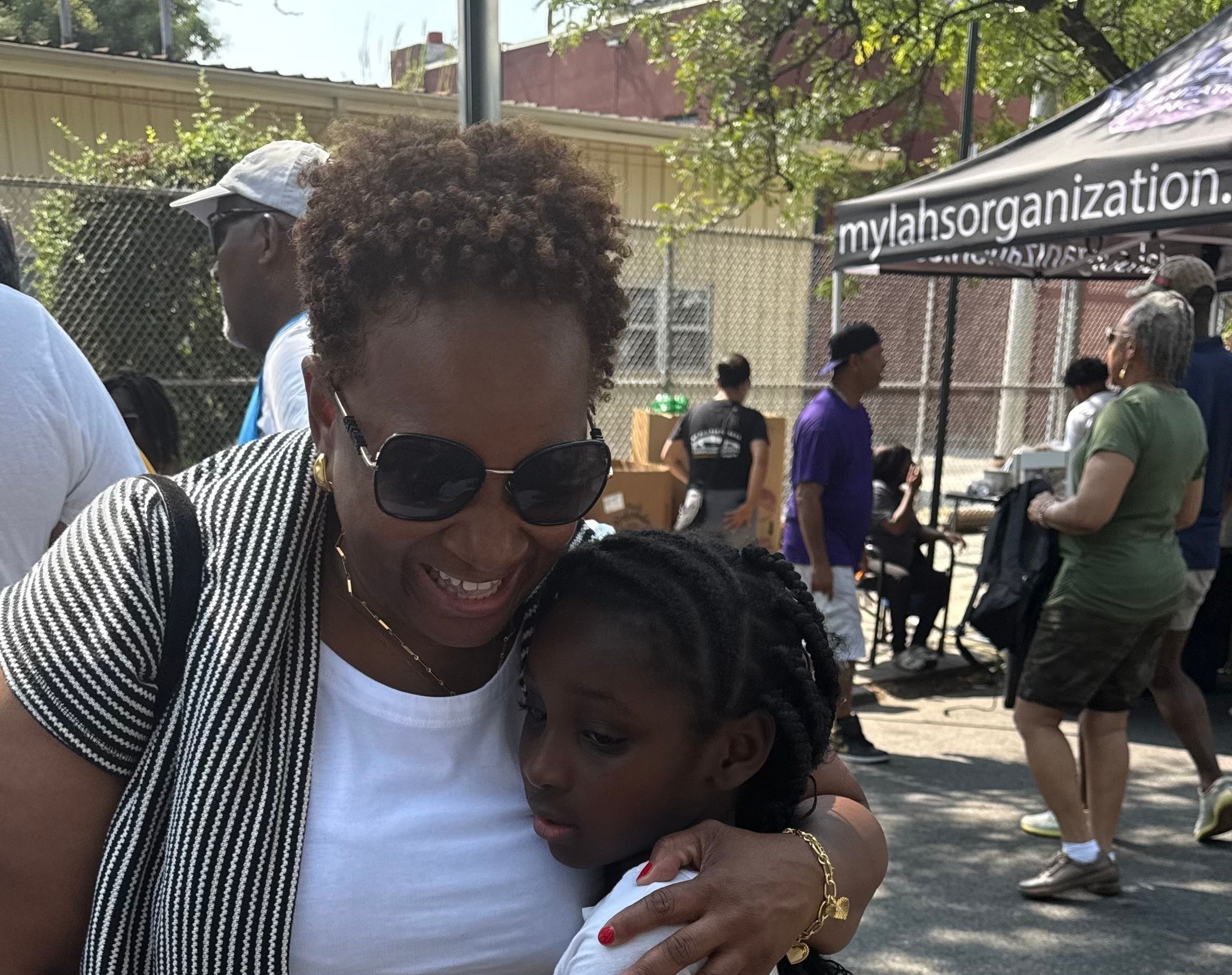 Nikki Lucas hugs young studnet at ENY Back to School giveaway